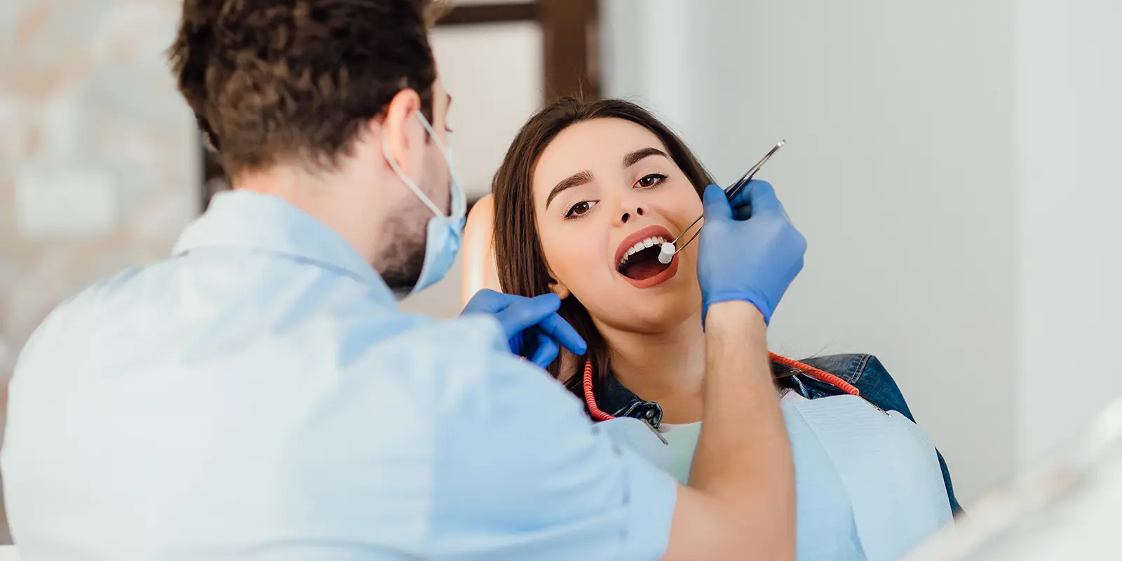 dentist-making-professional-teeth-cleaning-withb-cotton-female-young-patient-dental-office.webp